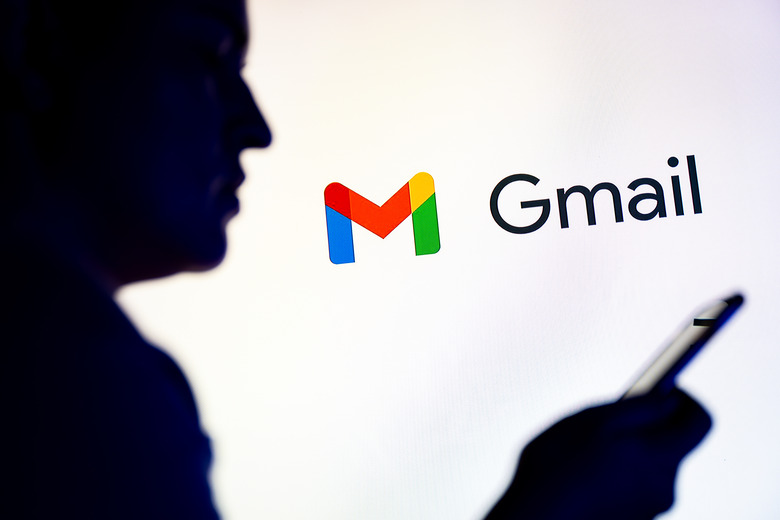 POLAND - 2025/11/26: In this photo illustration, a silhouetted individual is seen holding a mobile phone with a Gmail logo displayed in the background. (Photo Illustration by Mateusz Slodkowski/SOPA Images/LightRocket via Getty Images)