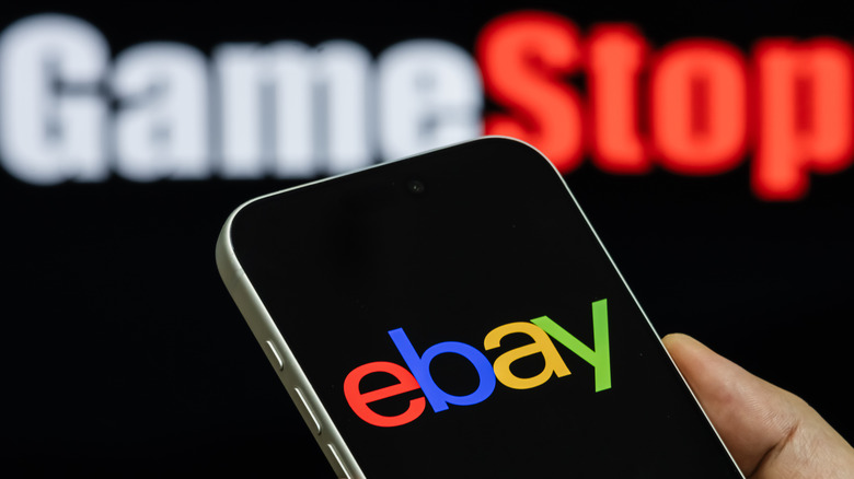 ebay logo shown on smartphone with GameStop logo in the background
