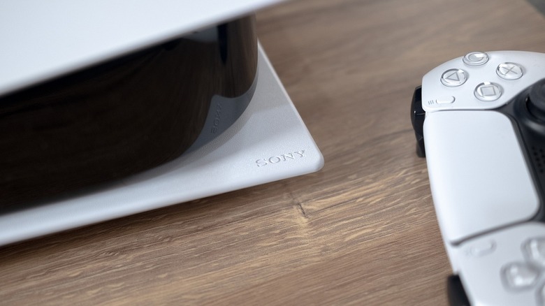 Close up of a Sony PlayStation 5 console and controller with Sony logo in center