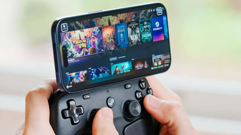 Hands holding a Steam Controller with a smartphone running the Steam Link app attached to the top.
