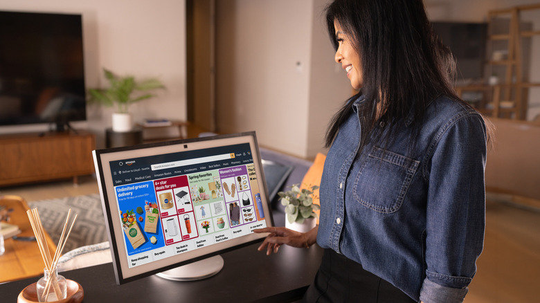 A person in front of a smart display showing the Amazon interface.